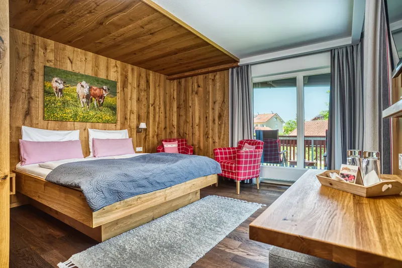 Hotelzimmer im alpinen Stil mit Doppelbett